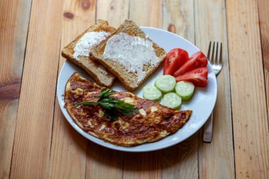 Ev mutfağında peynirli omlet pişiriyorum.