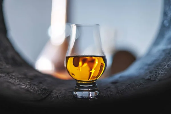 A glass of whiskey in oak barrel — Stock Photo, Image