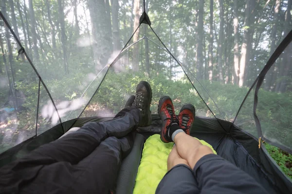 夏の森を背景にキャンプテント内の男性の足 — ストック写真
