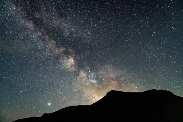 Dağlar, inanılmaz bir yıldızlı gökyüzünün arka planına karşı. — Stok fotoğraf