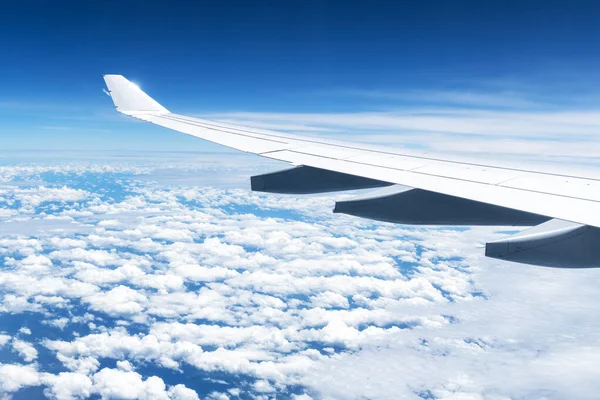 Blick auf Wolken und Flügel aus einem Flugzeugfenster — Stockfoto