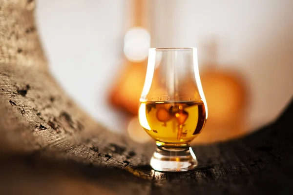 A glass of whiskey in oak barrel — Stock Photo, Image