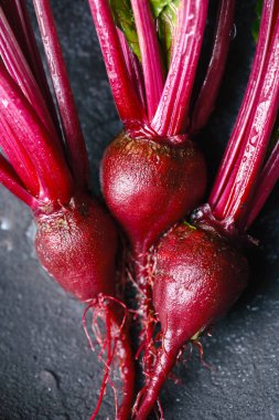 Sağlıklı sebzeler gibi koyu arka planda kökleri olan taze çiğ pancar. Doğal organik bitki kökü. Yakın plan.