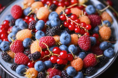 Karışık yaz meyvelerini kaseye koy, sığ alan derinliği. Taze organik çeşitlilik, canlı meyve dokusu