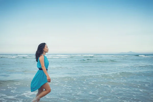 若い美しいアジアの女性は熱帯の海のビーチで海の水に沿って歩いています — ストック写真