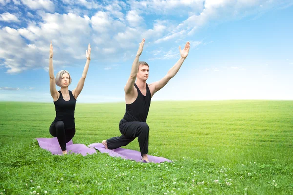 Yoga yaparken kadın ve erkek — Stok fotoğraf