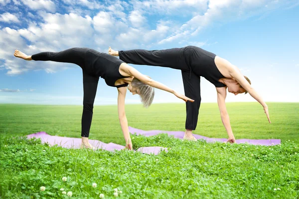 Hombre y mujer haciendo yoga —  Fotos de Stock