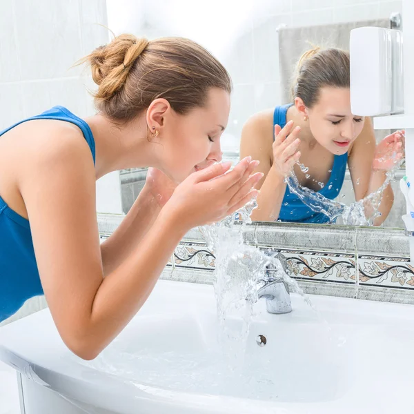 Giovane donna che si lava il viso — Foto Stock