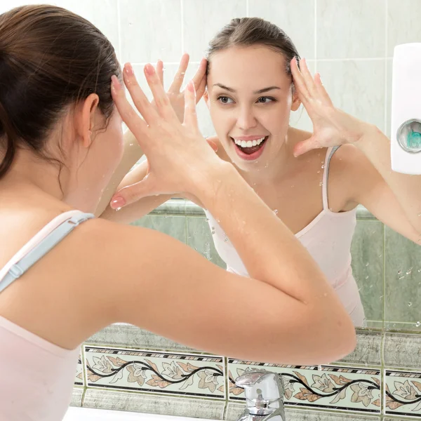 Junge Frau wäscht ihr Gesicht mit sauberem Wasser — Stockfoto