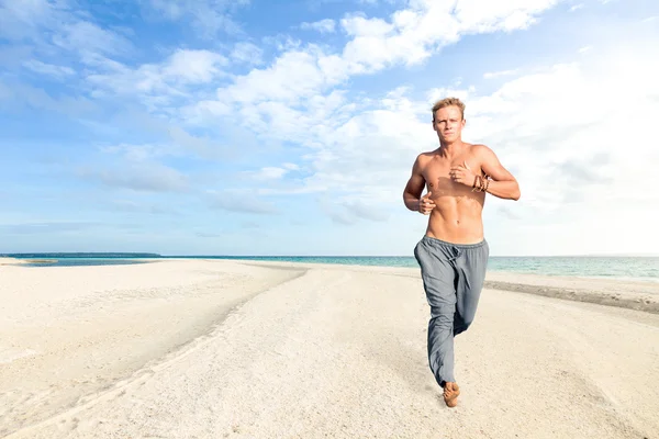 Homem correndo na areia da praia tropical — Fotografia de Stock