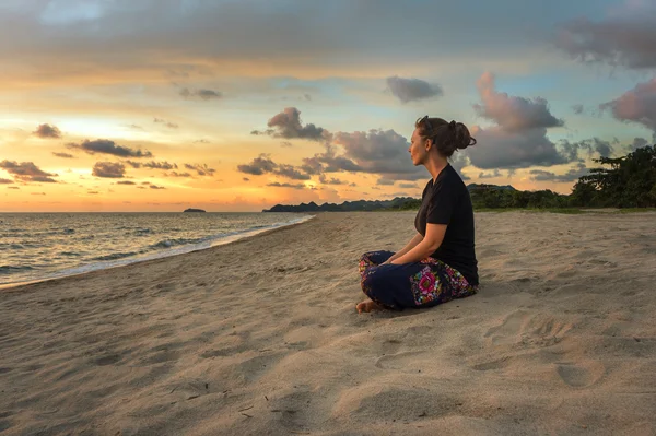 Žena relaxace na pláži při západu slunce — Stock fotografie
