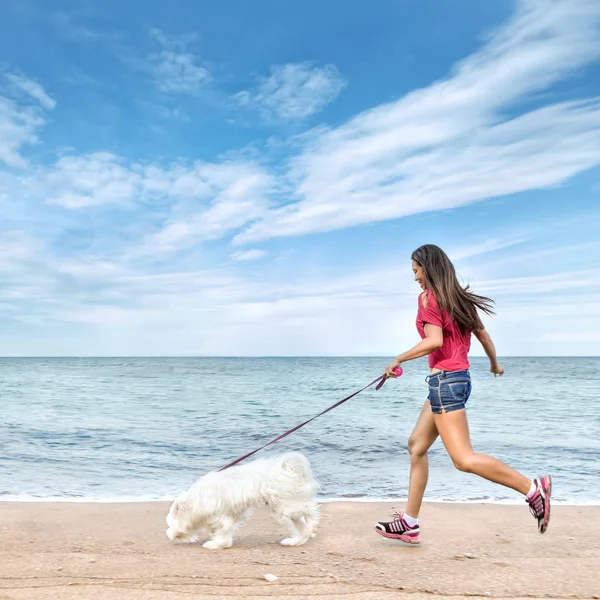 Jovem mulher caminhando com cão — Fotografia de Stock