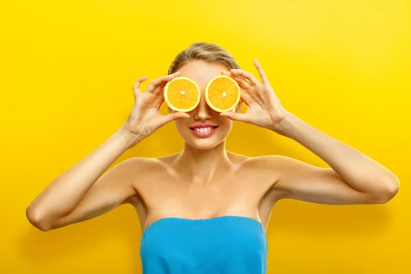 Jovem com frutas no fundo laranja brilhante — Fotografia de Stock