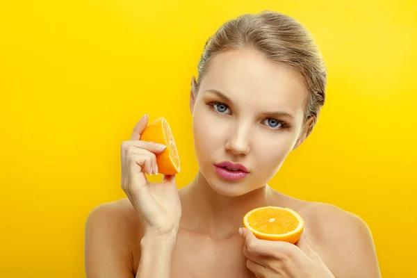 Jovem com frutas no fundo laranja brilhante — Fotografia de Stock