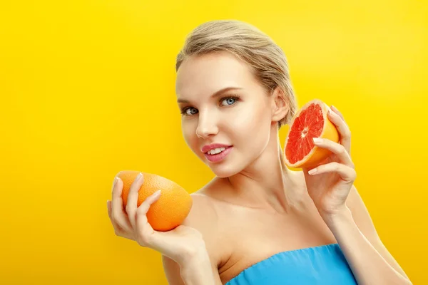 Jovem com frutas no fundo laranja brilhante — Fotografia de Stock