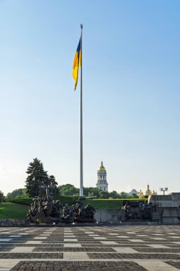 Ukrayna bayrağı havada dalgalanıyor. Kyiv. Rusya 'nın Ukrayna' ya karşı savaşı. Anavatanın ünlü heykelinin manzarası. Bağımsızlık. Özgür bir ülkenin kırılmaz başkenti..