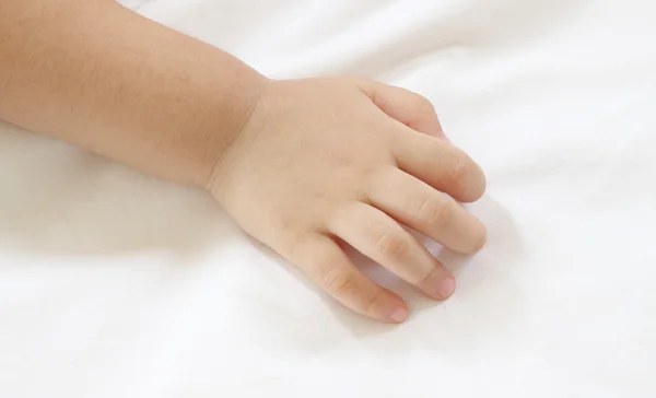 Back hand of asian baby on white bedcovers. — Stock Photo, Image