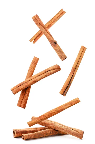 Cinnamon sticks fly and fall on a heap on a white background. Isolated — Stock Photo, Image