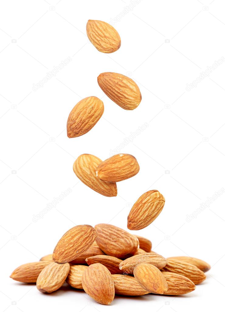 Almond nut flies and falls on a heap on a white background. Isolated