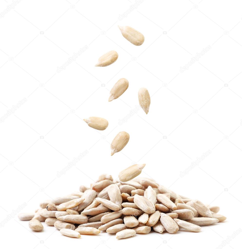 Sunflower kernels fall on a pile close-up on a white background. Isolated