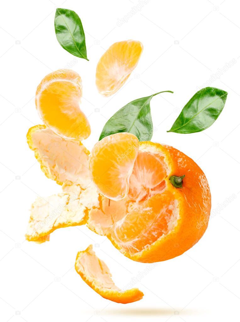 Peeled tangerine slices, leaves and rind fly close-up on a white background, isolated. Levitating Mandarin