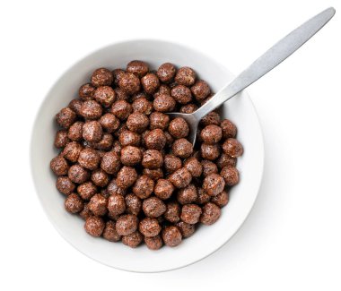 Mısır gevreği, beyaz arka planda kaşıkla tabakta çikolata topları. Üst görünüm.