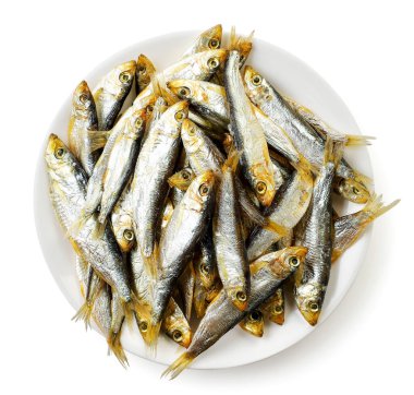 Beyaz bir arka planda, tabakta kurutulmuş füme küçük balık, tülka izole. Üst görünüm