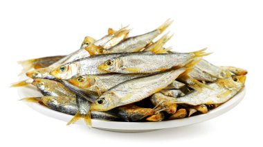 Beyaz arka planda yakın plan bir tabakta füme küçük balık. İzole edilmiş