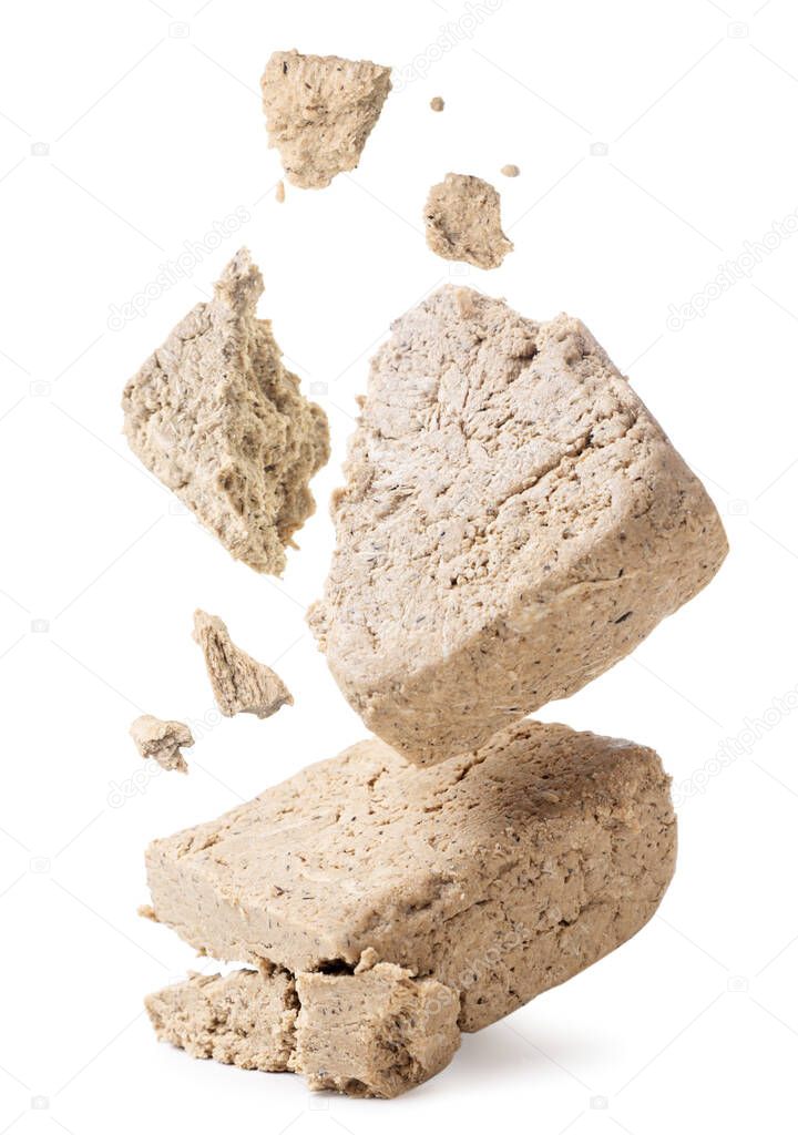 Halva broken into pieces falls on a white background. Isolated