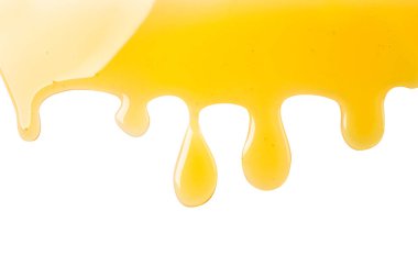 Beyaz bir zemin üzerinde bal damlaları akıyor, izole edilmiş. Üst görünüm.