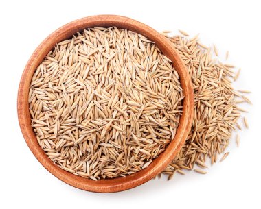 Ahşap bir tabakta soyulmamış yulaflar beyaz arka planda, izole edilmiş. Üst görünüm