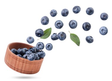 Böğürtlenler, beyaz bir arka planda, ahşap bir plakadan uçar, yaban mersinlerini havada uçurur. İzole edilmiş