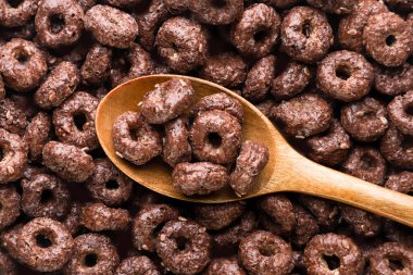 Tahta kaşıkta çikolatalı mısır halkaları, yakın plan, arka plan. Üst görünüm