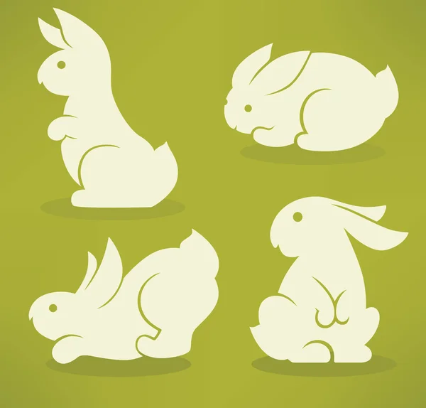 Silhouettes blanches de lapins de Pâques sur fond vert — Image vectorielle