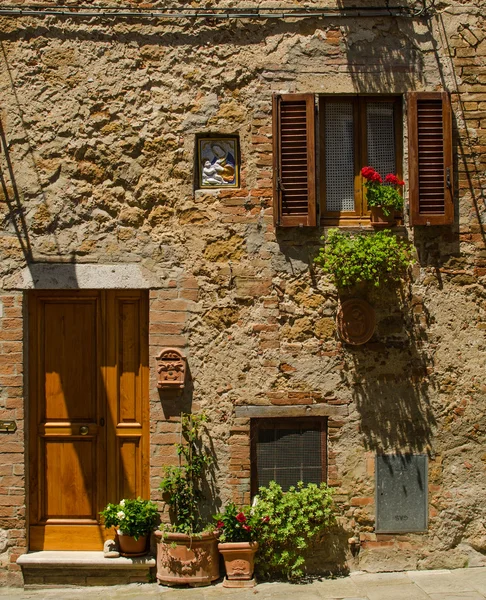 Een huis met raam en deur met bloemen van Pienza, Italië — Stockfoto