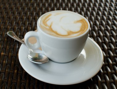 Kapuçino hasır masada bir fincan