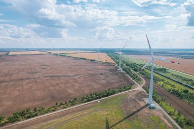 Rüzgar güç türbininin hava görüntüsü güzel bulutlu gökyüzünde popüler sürdürülebilir, yenilenebilir bir enerji kaynağıdır. Rüzgar güç türbinleri sürdürülebilir kalkınma için temiz yenilenebilir enerji üretiyor.