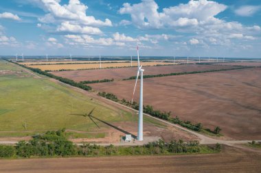 Rüzgar güç türbininin hava görüntüsü güzel bulutlu gökyüzünde popüler sürdürülebilir, yenilenebilir bir enerji kaynağıdır. Rüzgar güç türbinleri sürdürülebilir kalkınma için temiz yenilenebilir enerji üretiyor.