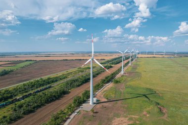 Rüzgar güç türbininin hava görüntüsü güzel bulutlu gökyüzünde popüler sürdürülebilir, yenilenebilir bir enerji kaynağıdır. Rüzgar güç türbinleri sürdürülebilir kalkınma için temiz yenilenebilir enerji üretiyor.