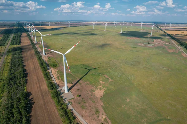 Widok z lotu ptaka Turbina wiatrowa jest popularnym, zrównoważonym, odnawialnym źródłem energii na pięknym zachmurzonym niebie. Turbiny wiatrowe wytwarzające czystą energię odnawialną dla zrównoważonego rozwoju. — Zdjęcie stockowe