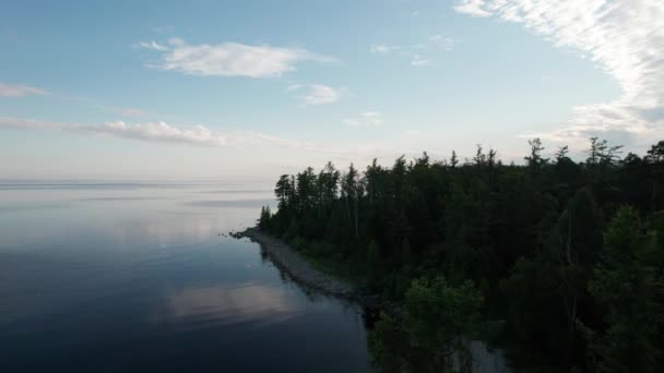 Epische filmische luchtfoto uitzicht Lake Baikal in de ochtend. Turkoois water in een bergmeer met dennenbomen. Uitzicht vanuit de lucht op het blauwe meer en groene bossen. Uitzicht op het meer tussen bergbos. — Stockvideo