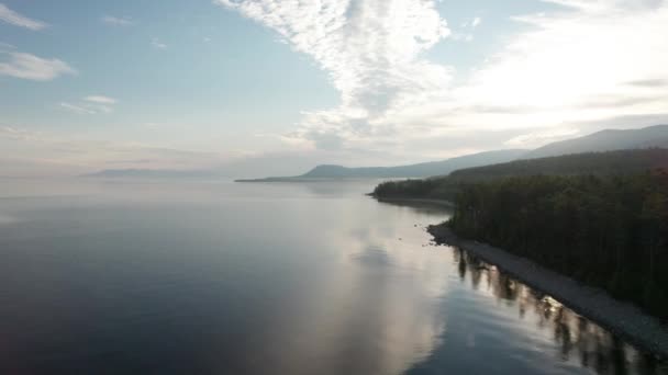 Episk filmisk flygbild Lake Baikal på morgonen. Turkos vatten i en fjällskogssjö med tallar. Flygfoto över blå sjö och gröna skogar. Utsikt över sjön mellan fjällskog. — Stockvideo