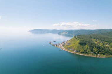 Baykal Gölü manzaralı dağlar ve ormanlar tarafından çerçevelenmiş olağanüstü mavi bir mücevherdir. Efsanevi sinematik hava manzaralı Baykal Gölü. Mavi göl ve yeşil ormanların havadan görünüşü.