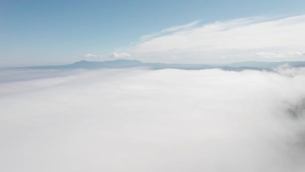 Hegycsúcsok fölött repülnek a felhők között. Magas csúcsok csodálatos reggeli napkelte természetes táj — Stock videók