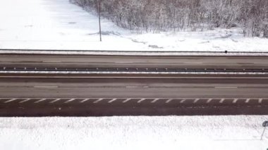 Kış zamanı, tepeden aşağıya doğru karlı bir yol çam ağacı ormanını çevreleyen.