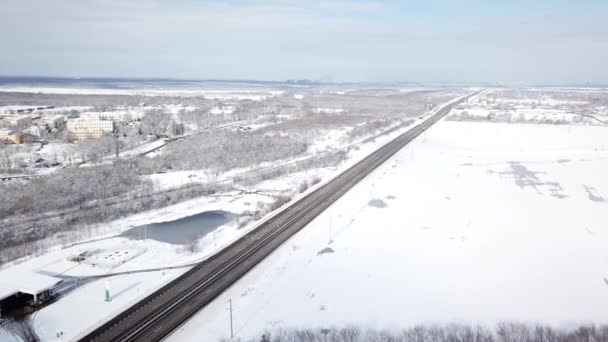 Vintertid antenn topp ner utsikt över en snöig väg omgiven tallskog — Stockvideo