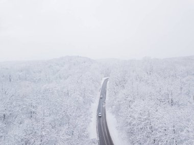 Drones Eye View - Güney Rusya 'daki yüksek dağ geçidinden gelen kış virajı yolu. Yoğun ormanda harika bir yolculuk..