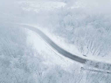 Drones Eye View - Güney Rusya 'daki yüksek dağ geçidinden gelen kış virajı yolu. Yoğun ormanda harika bir yolculuk..