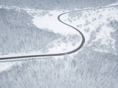 Drones Eye View - Güney Rusya 'daki yüksek dağ geçidinden gelen kış virajı yolu. Yoğun ormanda harika bir yolculuk..