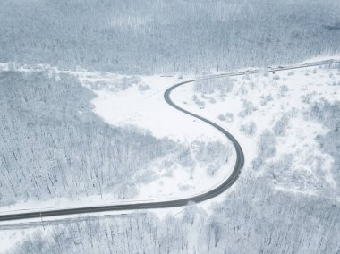 Drones Eye View - Güney Rusya 'daki yüksek dağ geçidinden gelen kış virajı yolu. Yoğun ormanda harika bir yolculuk..